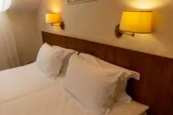 Двуспальная кровать в номере гостиницы «Двор Подзноева» в Пскове