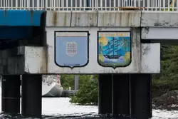 Доска объявлений и герб Сен-Мартена на мосту в залив Симпсон Бей