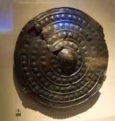 Бронзовый щит, 1200-900 г. до н.э. — кованые металлические щиты делали их владельцев более важными, но были малополезны в бою, вместо этого использовались крепкие кожаные и деревянные щиты