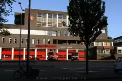 Пожарная станция и выезжающие из неё пожарные машины с ужасно громкими сиренами