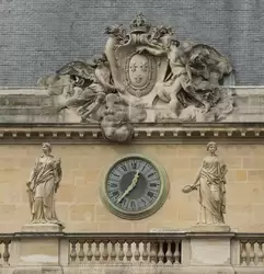 Герб Франции — три лилии и часы на фасаде Дворца Правосудия в Париже